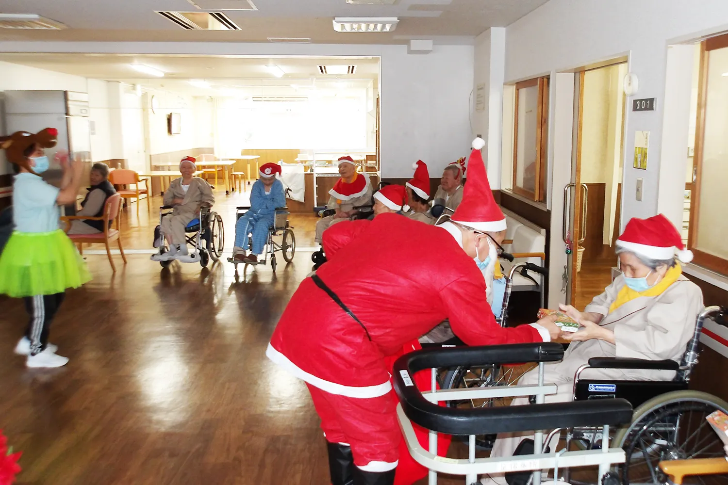 足摺病院の病棟で、クリスマスに職員がサンタの姿で患者さんへプレゼントを届けている様子