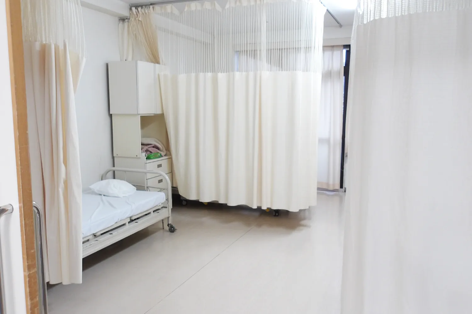 足摺病院の病室内の様子。カーテンで区切られた清潔感のある療養スペース